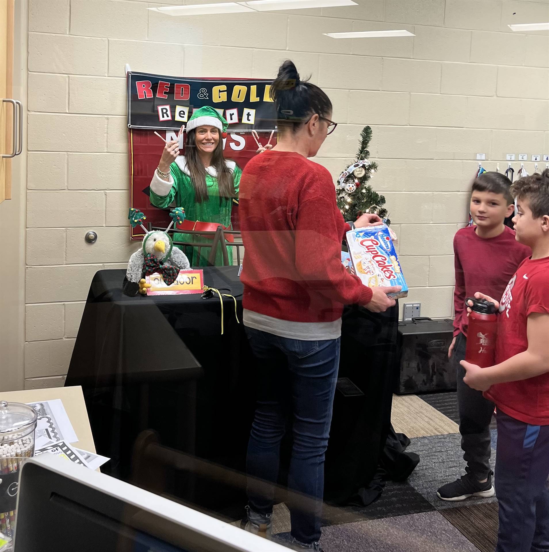 Mrs Crawford dressed as the elf is posed behind the children for the morning announcements