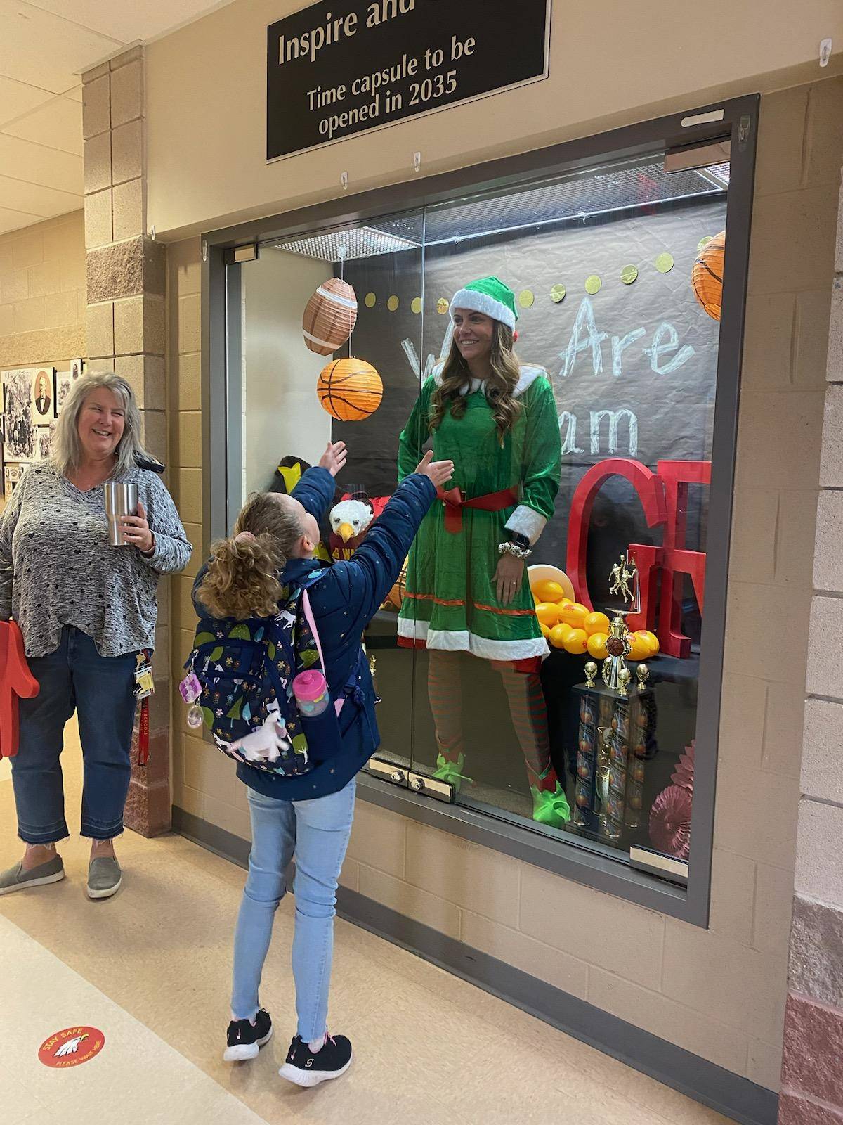Principal Crawford is dressed as Elf on the Shelf as kids enter the bulding