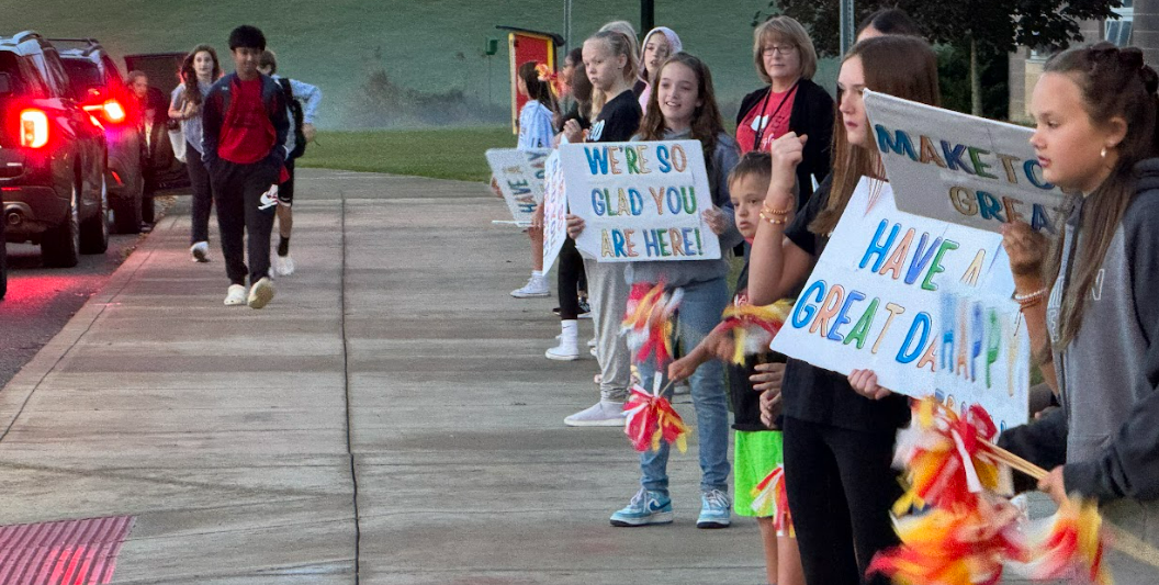 Big Walnut Intermediate School students greet other students with signs entering school