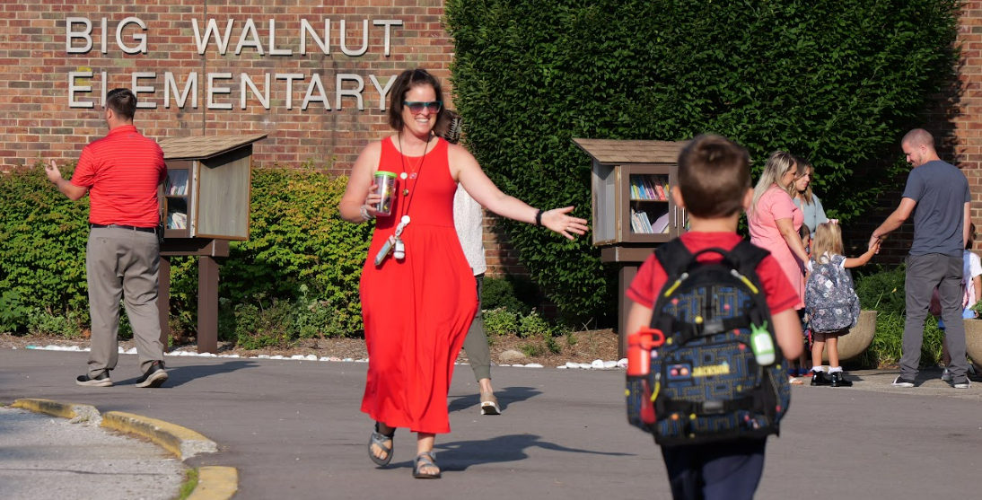 A teacher greets a student in front of Big Walnut Elementary