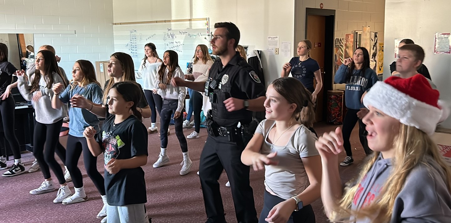 School Resource Officer dances with students in a classroom activity