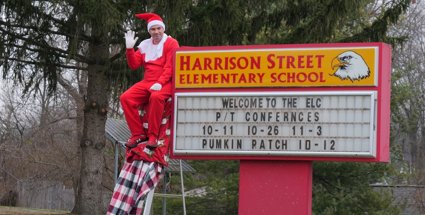 Superintendent Ryan McLane poses as an elf in front of The Early Learning Center
