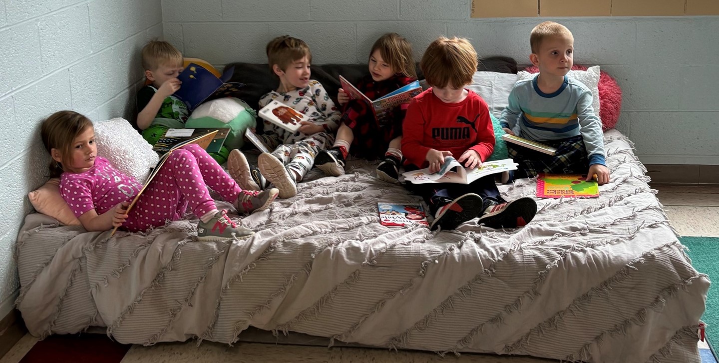 Students in the Early Learning Center reading together on a couch bed