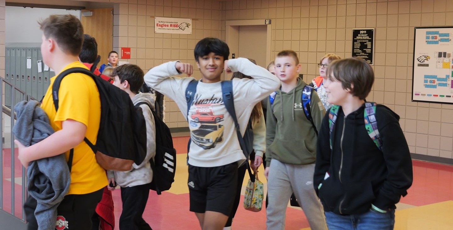 a Big Walnut Intermediate student flexes for the camera in the hall