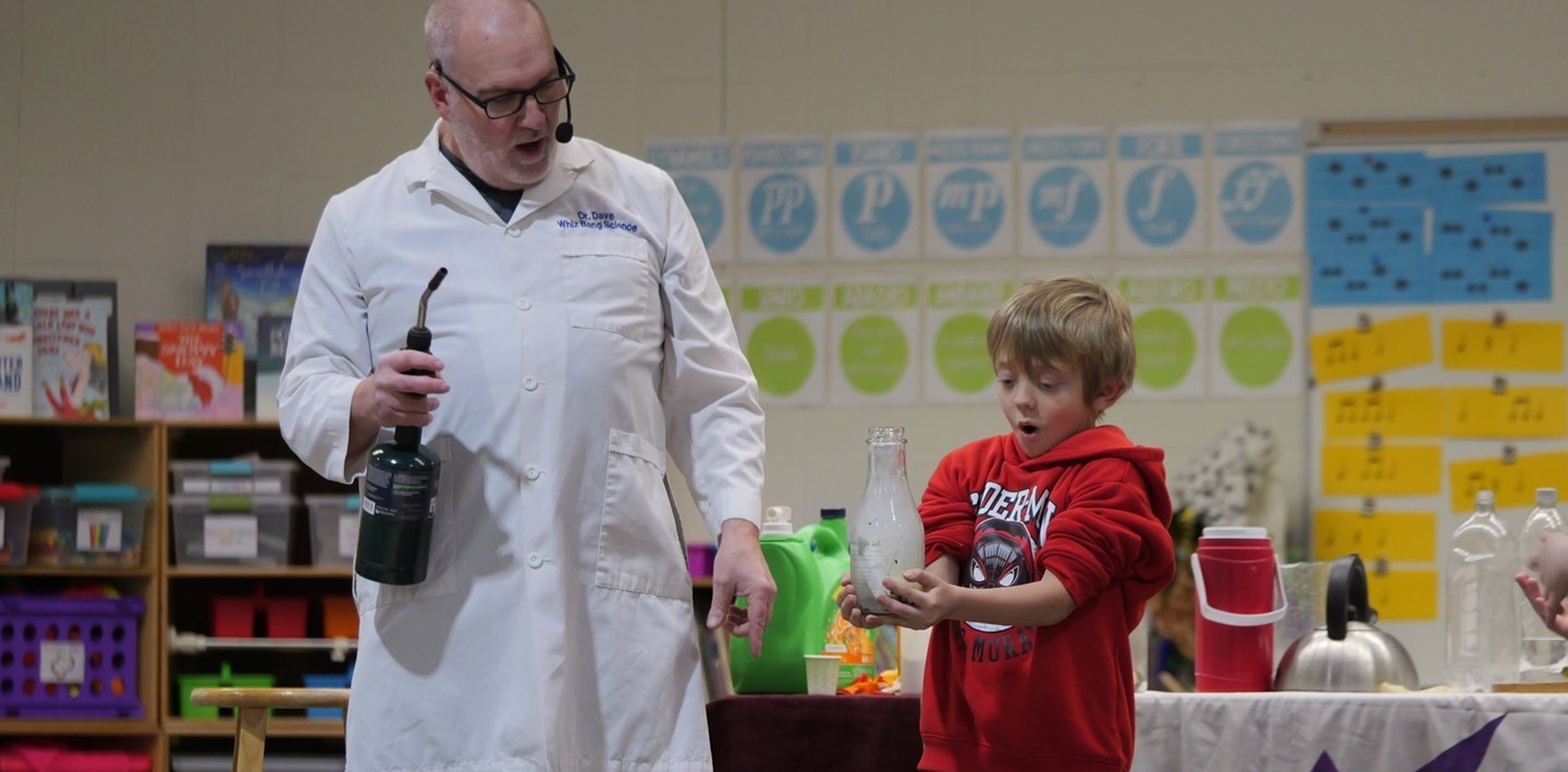 A student is amazed at an experiment done on stage