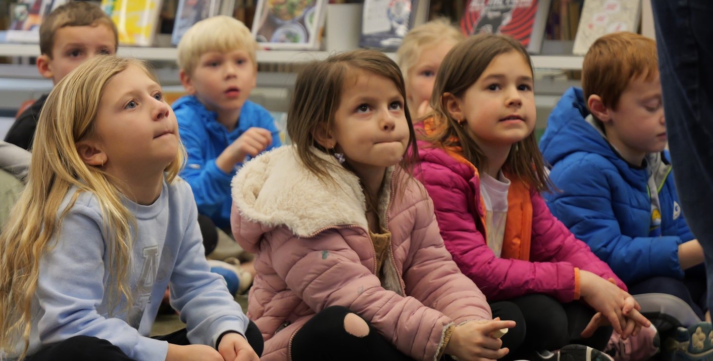 Students listen during a story time at the library