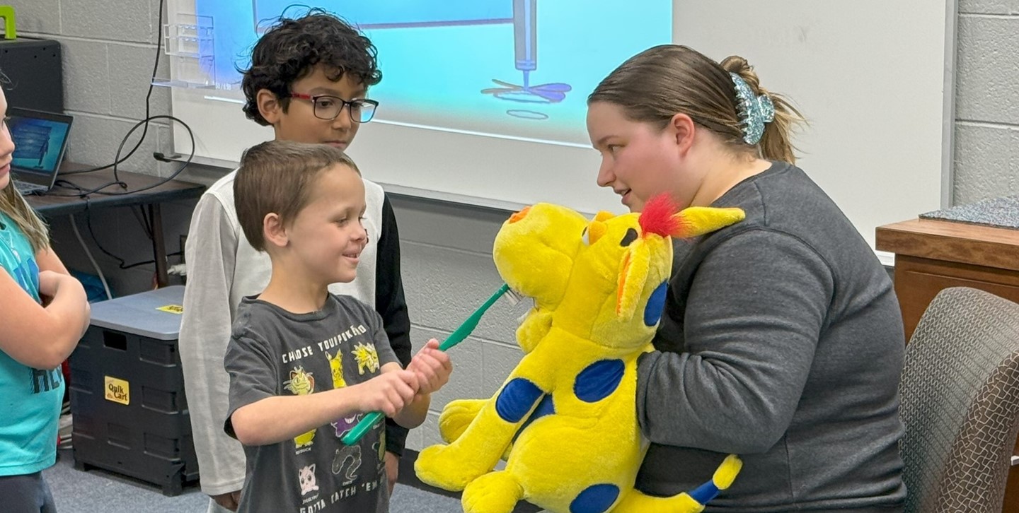 Students practice brushing their teeth