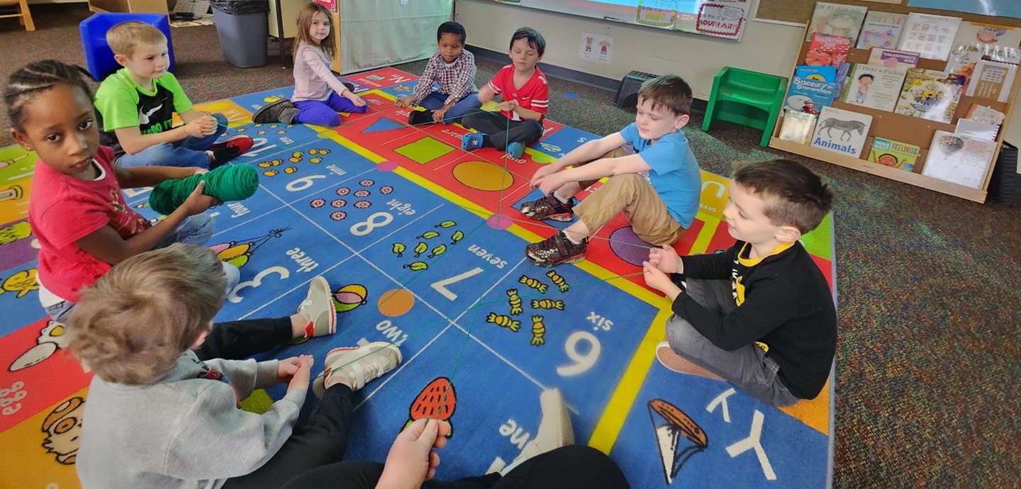 Students sit and pass around toys